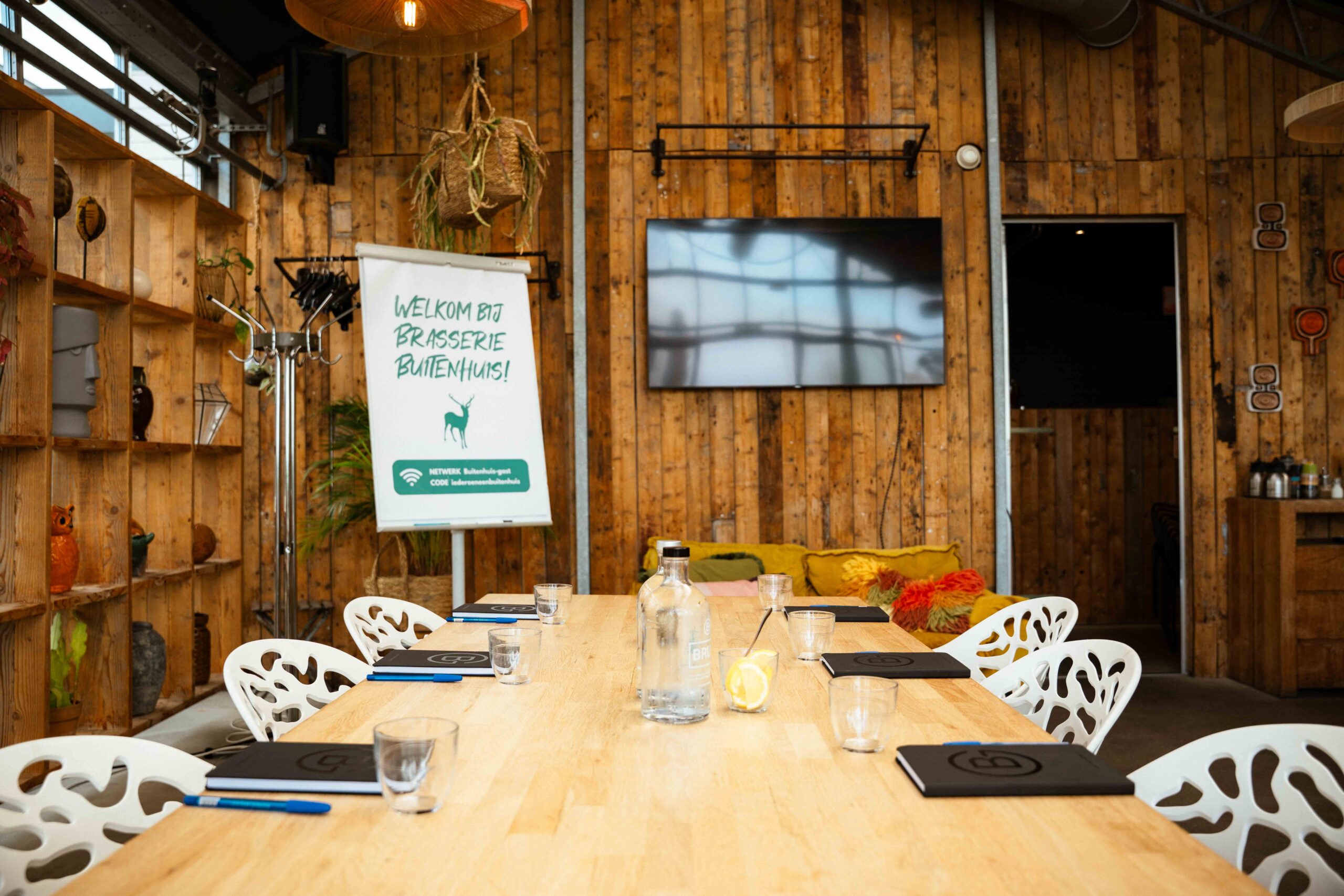 Vergadertafel met scherm in een zaal met houten wanden bij Brasserie Buitenhuis in Valkenburg